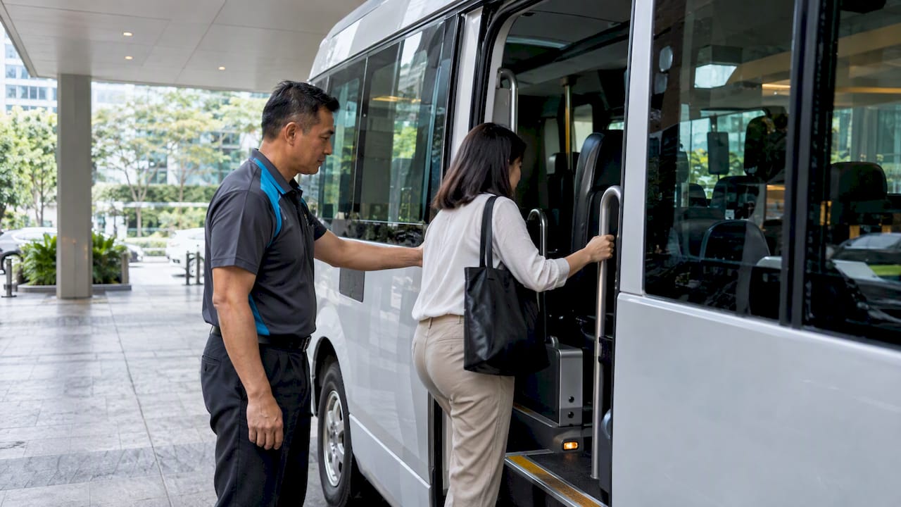 Chauffeur greeting passenger at sheltered office pickup